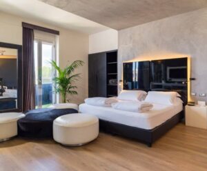 camera d'hotel con letto, pouf e ogni comfort una hotels one siracusa