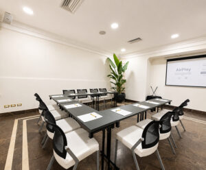 sale meeting community one world b con tavolo a U, sedie attorno e proiettore una hotels one catania siracusa